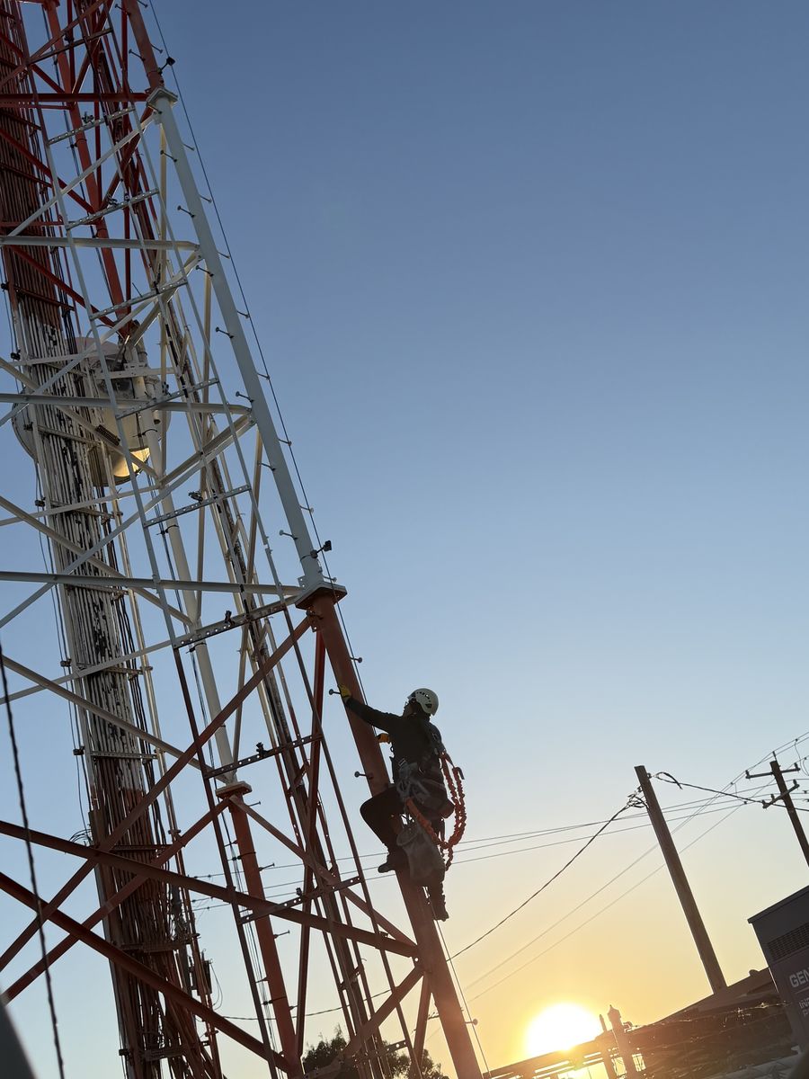 CVI technician climbing a tower at sunset